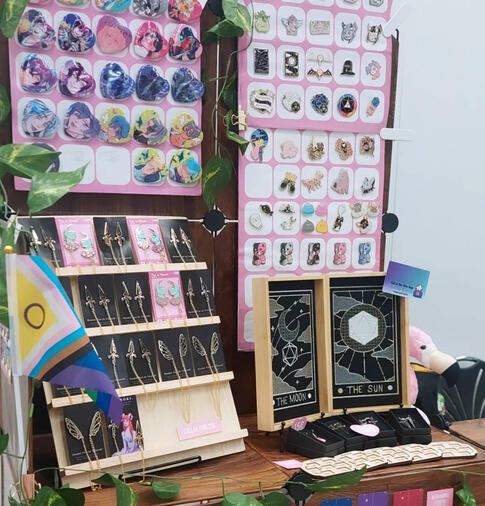 Artist Alley Booth with Enamel Pins, Buttons and Dicetrays