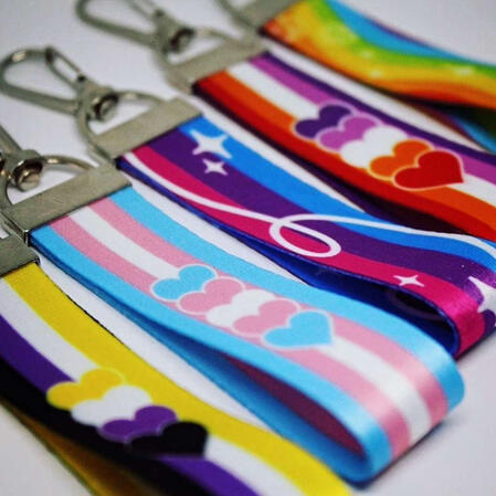 Lanyards 5 mini lanyards next to each other with various pride flags on them including the nonbinary flag, the trans flag, the bi flag, the lesbian flag and the rainbow flag